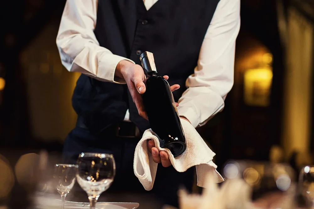 Kellner präsentiert eine Weinflasche in einem Restaurant