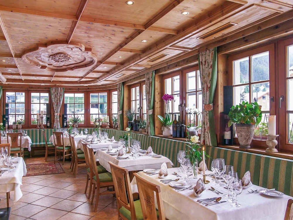 Hotel Salnerhof | 4 Sterne Superior in Ischgl Gemütlicher Restaurantbereich mit Holzmöbeln und eingedeckten Tischen