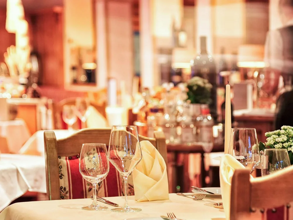 Hotel Salnerhof | 4 Sterne Superior in Ischgl Gedeckter Tisch mit Weingläsern und Servietten in einem gemütlichen Restaurant
