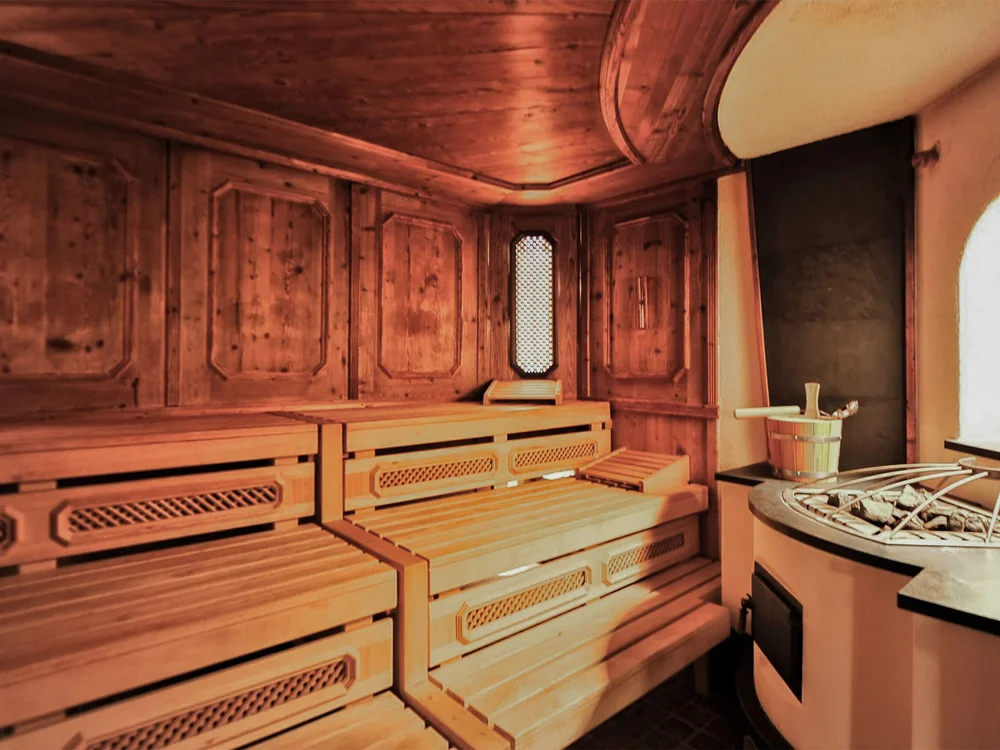 Hotel Salnerhof | 4 Sterne Superior in Ischgl Holzsauna mit Bänken und Saunaofen neben einem Fenster