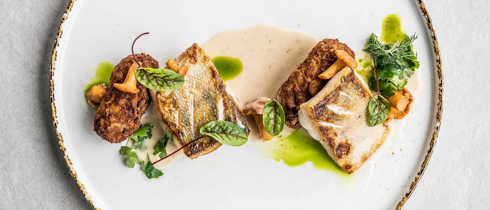 Hotel Salnerhof | 4 Sterne Superior in Ischgl Kunstvoll angerichteter Fisch mit Pilzen und grünen Kräutern auf weißem Teller
