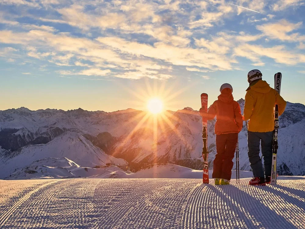 Hotel Salnerhof | 4 Sterne Superior in Ischgl Zwei Skifahrer stehen auf schneebedecktem Berg bei Sonnenuntergang
