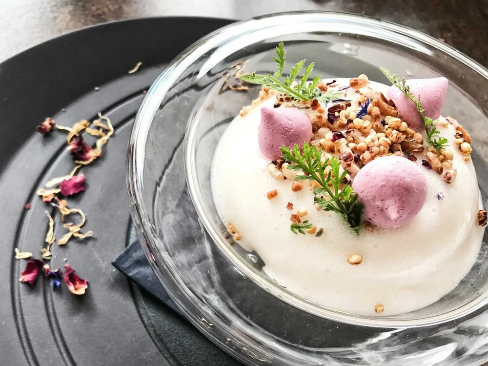Hotel Salnerhof | 4 Sterne Superior in Ischgl Dessert mit Schaum, rosa Baiser und Kräutern in Glasschale auf schwarzem Teller