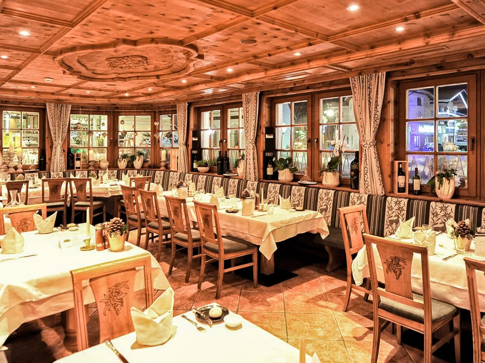 Hotel Salnerhof | 4 Sterne Superior in Ischgl Gemütliches Restaurant mit Holzmöbeln und gedeckten Tischen